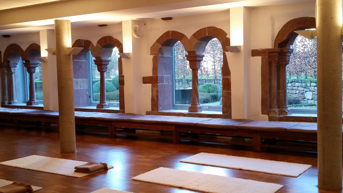 Meditationshalle (Zendo) mit Rundbogenfenstern und Sitzmatten