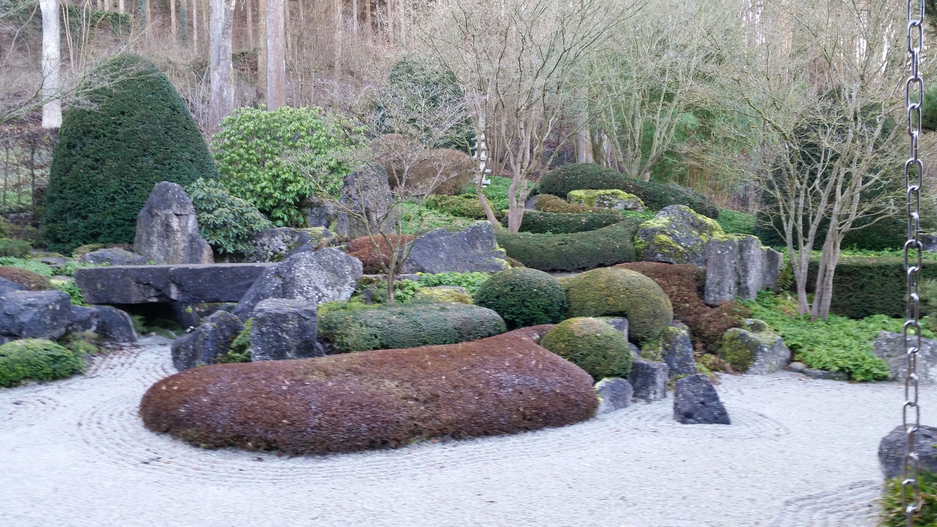 Zen-Garten des Benediktushofs mit Kies, Steinen und geschnittenen Büschen