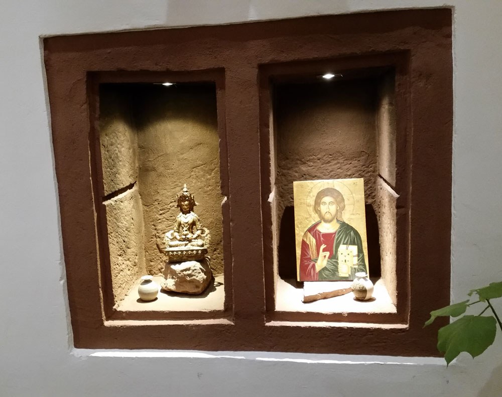 Wandnische im Benediktushof mit Buddha-Figur und Christus-Ikone