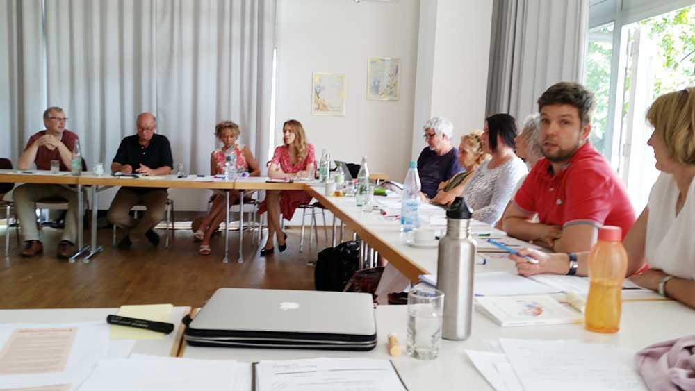 Arbeitsrunde der TextWerkstatt mit Laptops und Unterlagen