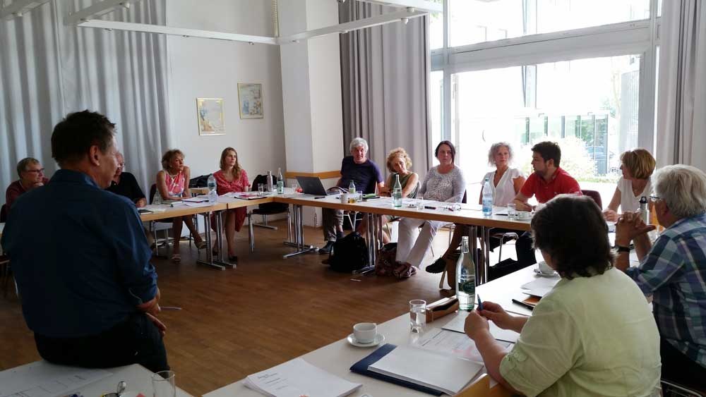 Teilnehmende der TextWerkstatt in einer großen Tischrunde
